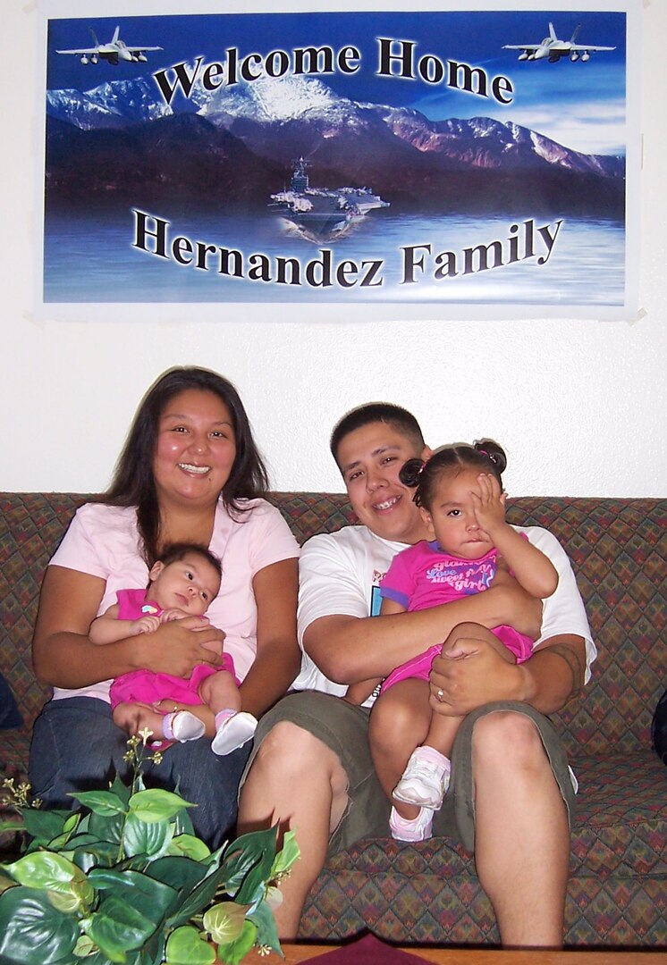 Petty Officer 1st Class Michael Hernandez, his wife Nellie, and daughters Emma, left, and Nina relax in their new home following a July 6 house fire.