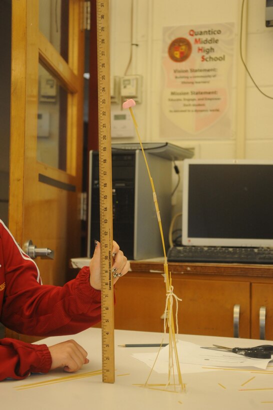 Ninth grade students from Quantico Middle/High School, aboard Marine Corps Base Quantico, build a 23 inch tower out of raw spaghetti noodles, string, tape, and a marshmallow on May 9, 2013, during the Science, Technology, Engineering and Mathematics event. Tower-building was a station designed to promote teamwork and to help the students apply learned concepts.