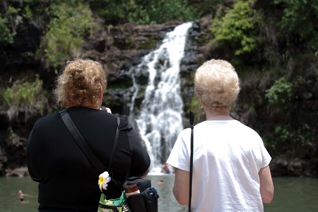HALEIWA, Hawaii — Two women admire Waimea Falls in Waimea Valley, April 28. There are paved trails winding through a canopy of trees in a peaceful tropical forest, leading to a beautiful 45-foot waterfall and swimming hole. (U.S. Marine Corps photo by Lance Cpl. Janelle Y. Chapman) 