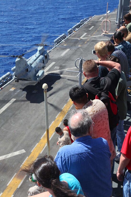Servicemembers, their families and friends view an air-power display aboard USS Peleliu, May 9. During the last leg of the deployment, guests came aboard the ship to experience life on the Peleliu and to learn what their Marine or sailor has accomplished during the past seven months. The 15th Marine Expeditionary Unit is comprised of approximately 2,400 Marines and sailors and is deployed as part of the Peleliu Amphibious Ready Group. Together, they provide a forward-deployed, flexible sea-based Marine Air Ground Task Force capable of conducting a wide variety of operations ranging from humanitarian aid to combat. (U.S. Marine Corps photo by Cpl. Timothy Childers / Released)