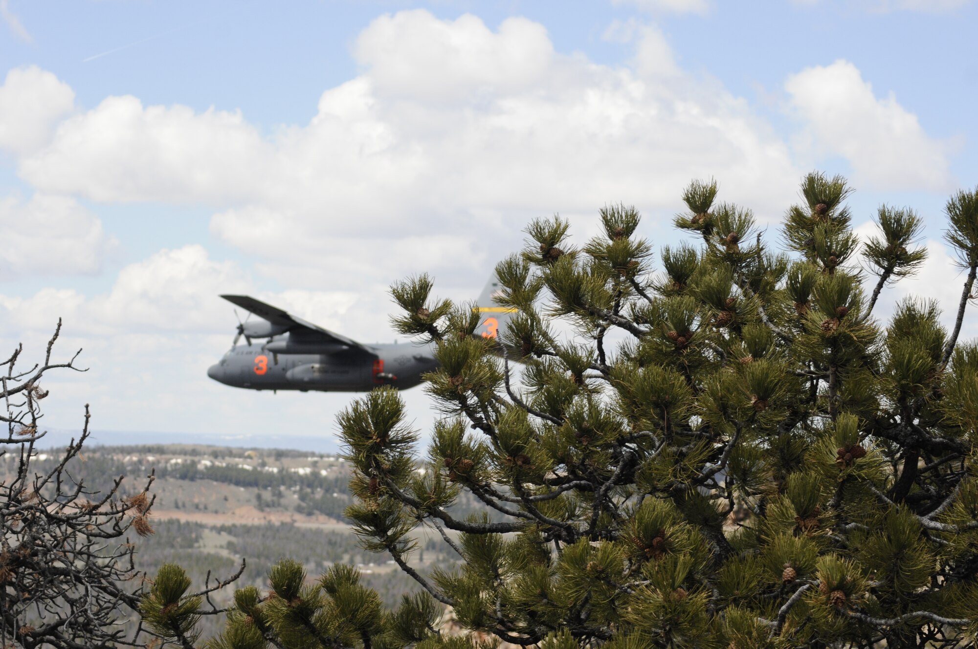 A Modular Airborne Fire Fighting System-equipped C-130 from the 153rd Airlift Wing, after following a U.S. Forest Service lead plane, performs a training mission which includes water drops near the Medicine Bow National Forest, May 10, 2013. The Wyoming Air National Guard's 153rd AW held its annual MAFFS certification and re-certification training. When it is determined MAFFS is needed, the National Interagency Fire Center through U.S. Northern Command requests the Department of Defense's U.S. Air Force resources. (U.S. Air National Guard photo by Capt. Rusty Ridley)