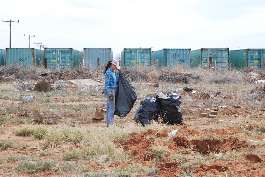 U.S. Air Force Senior  Airman  Jerica Morgan, 27th Special Operations Contracting Squadron contract specialist, gathers trash bags on Highway 60/84 between Cannon Air Force Base, N.M., and Clovis, N.M., May 8, 2013.  So far, more than 50 Air Commandos have volunteered in the community beautification project to clean the four-mile stretch of road over the next several months. (U.S. Air Force photo/Desiree Ann Montenegro)