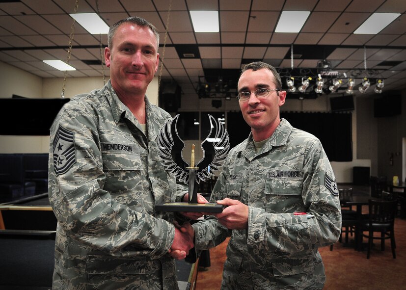 U.S. Air Force Chief Master Sgt. Paul Henderson, 27th Special Operations Wing command chief, presents Staff Sgt. Stephen Ross, 27th Special Operations Maintenance Squadron avionics, with the Airmen Against Drunk Driving Volunteer of the Quarter award in the Drop Zone at Cannon Air Force Base, N.M., May 9, 2013. Ross contributed more than 300 hours of service and saved more than a dozen wingmen from resorting to driving under the influence during the months of January through March 2013. (U.S. Air Force photo/Senior Airman Alexxis Pons Abascal) 

