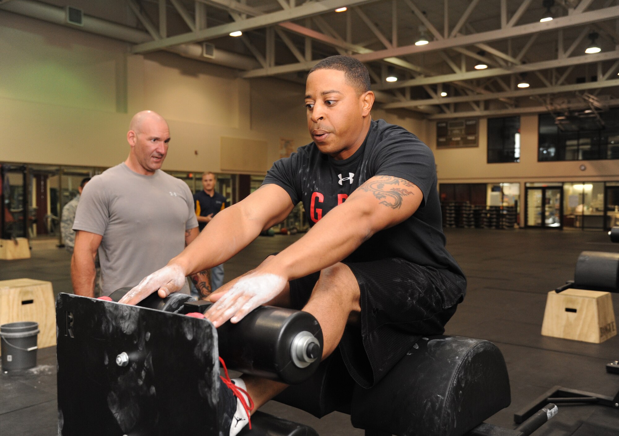 Al Ciampa, 81st Aerospace Medicine Squadron, watches Staff Sgt. Marcus Hyatt, 334th Training Squadron, doing situps to ensure he does them correctly during the warfighter fitness challenge May 9, 2013, at the Dragon Fitness Center, Keesler Air Force Base, Miss.  The timed challenge also consisted of completing activities such as pullups, pushups and a 40-yard kettle bell “farmer’s walk.”   Hyatt placed third in the challenge with an overall time of 2 minutes, 29 seconds.  The event was part of Keesler’s support for national sports and fitness month.  (U.S. Air Force photo by Kemberly Groue)