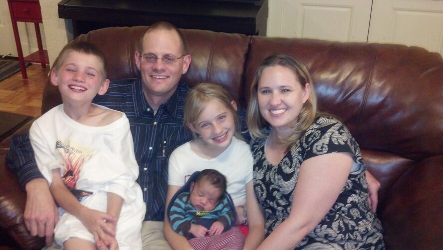 Maj. Bradley Henderson, Air Force Global Strike Command Judge Advocate office, poses with his wife, Janae, and their three children Mareila, Taemon and Curtis. The Hendersons adopted Curtis in Fayetteville, Ark., in April. 