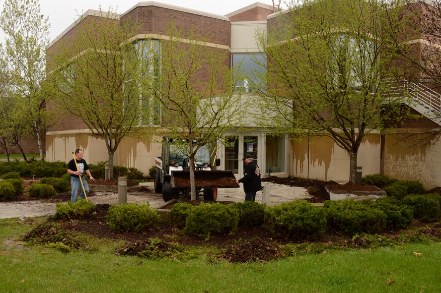 Pete Guittari, left, and Master Sgt. Greg Anderson, right, rakes the old mulch out of the garden beds in St. Paul, Minn., May 9, 2013. Guittari and Anderson are participating in the annual base-wide cleanup and maintenance of the 133rd Airlift Wing. 
(U.S. Air Force photo by Tech. Sgt Amy M. Lovgren/Released)
