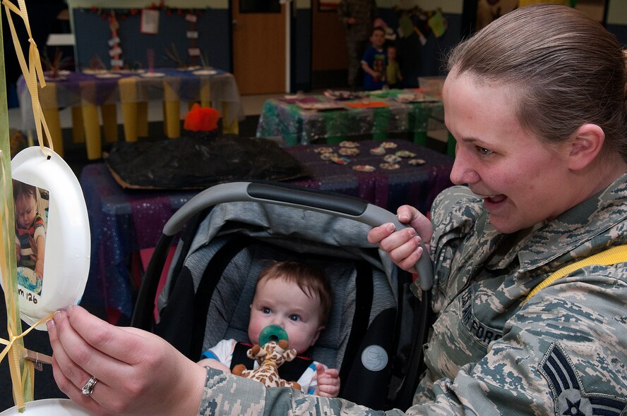 Senior Airman Karen Klein, 153rd Logistics Readiness Squadron, shows her son, Christopher, 6 months, his art work displayed in the F. E. Warren Child Development Center art show April 26. The CDC exhibited the work of the children using the facility as part of their observation of the Month of the Military Child. (U.S Air Force photo by R.J. Oriez)