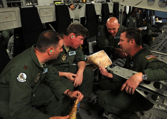 Aircrew members  from the 326th Airlift Squadron, Dover Air Force Base, Del., fly en route to Nellis Air Force Base, Nev., and discuss a low-altitude training mission planned to influence future Red Flag exercises May 3, 2013. The crew was part of an eight-person team charged with conducting a noncombatant evacuation operation exercise during the 512th Airlift Wing's unit training assembly. (U.S. Air Force photo by Senior Airman Erika Brooke)