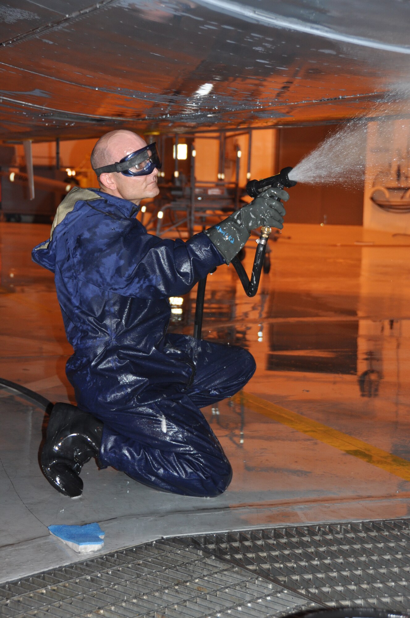 Staff Sgt. Ryan Harris, 507th Aircraft Maintenance Squadron crew chief rinses soap off the belly of a KC-135 Stratotanker which was scheduled for its routine wash on May 5, 2013 in the hanger known as the fuel barn.

Aircraft go through a general wash cycle of 180 days unless they are sent into more corrosive environments.  Depending on the kind of environment the wash cycle changes to either 30, 60 or 120 days.  Flights conducted in salt water areas would be scheduled more often to ensure the salt does not corrode any parts.  

Although the aircraft is generally washed with aircraft soap and hot water, some chemicals are authorized for specific needs.

Once the entire aircraft has been thoroughly washed and rinsed, the joints and other parts will get re lubricated and inspected.

This aircraft being washed during the May Unit Training Assembly is good training for traditional reservists.  It not only gives them a chance to perform a through and proper wash along with re lubricating joints and other parts, but also gives them a chance to properly follow instructions from the technical order provided for a proper wash.  (U.S. Air Force photo by Senior Airman Mark Hybers)

