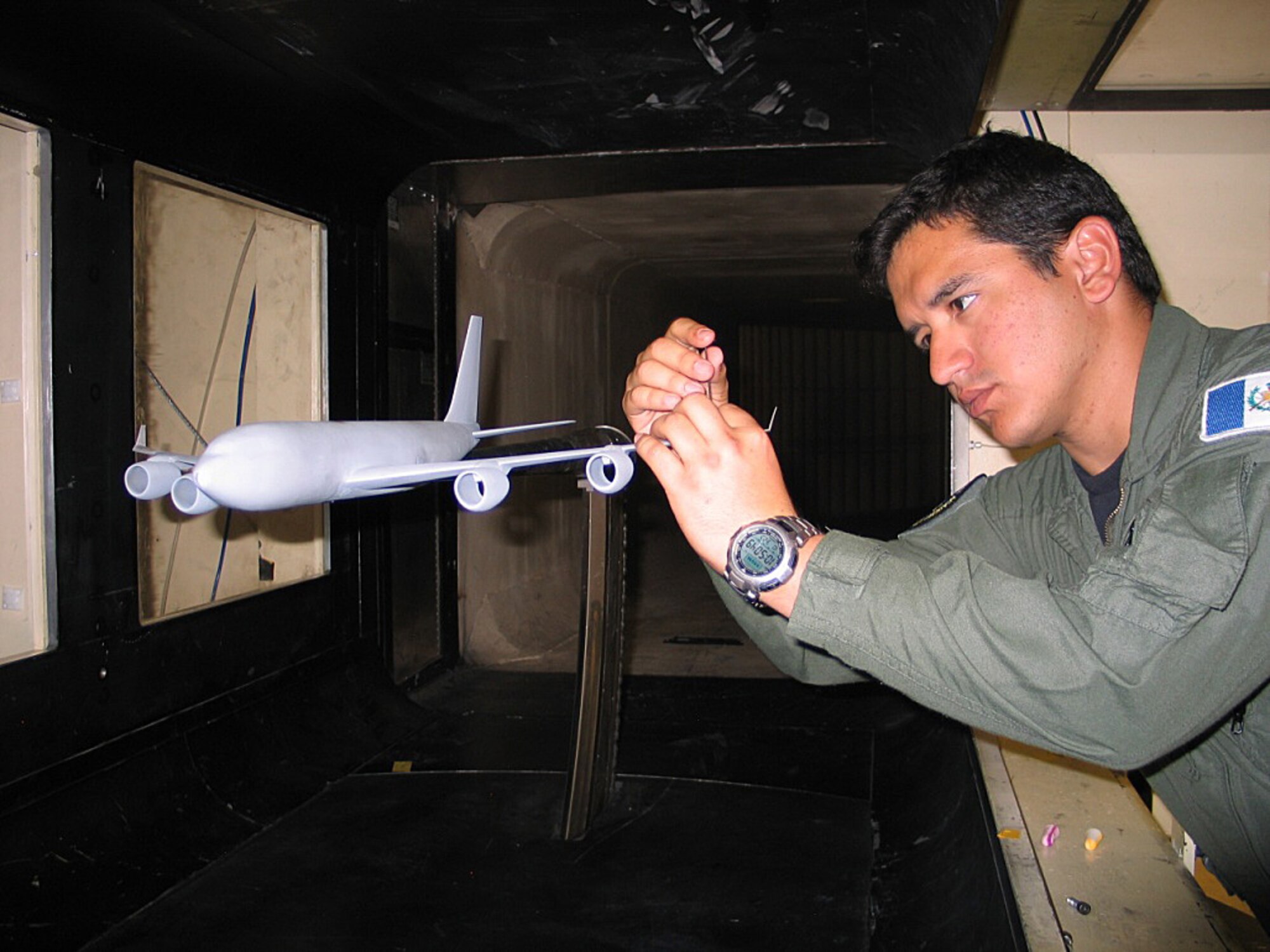 Mario Avila Diaz adjusts a wind tunnel used to test the rakelet concept in the Air Force Academy's aeronautics laboratory. The U.S. Patent Office awarded a patent for the wingtip design, which improves fuel efficiency on the KC-135 Stratotanker. The fuel conserved could save the Air Force as much as $34 million per year. Avila Diaz, a Guatemalan exchange cadet, graduated from the Academy in 2011. (U.S. Air Force photo/Ken Ostasiewski)