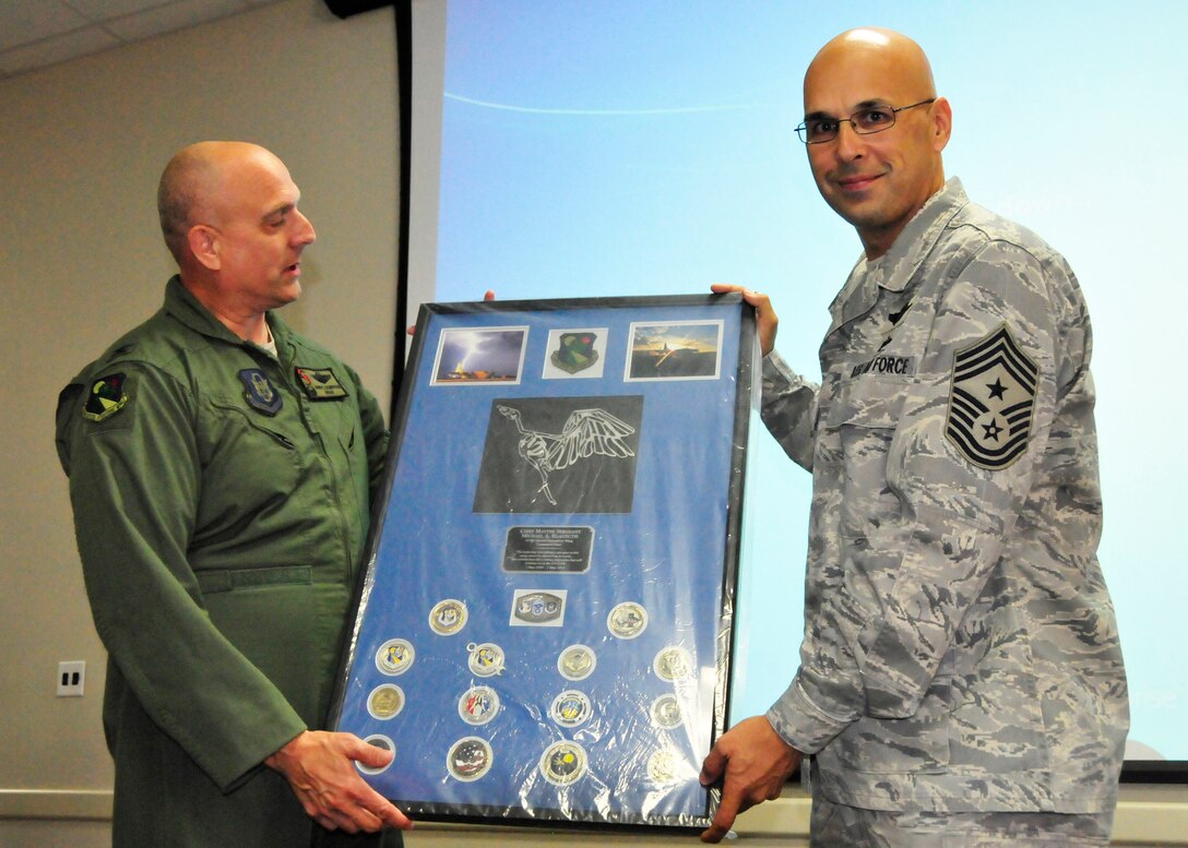 Col. Andy Comtois, commander of the 919th Special Operations Wing, reads the inscription on a special memento presented to Chief Master Sgt. Michael Klausutis, outgoing 919th SOW command chief, during his sendoff event May 4, 2013 at Duke Field, Fla.  Since April 2009, Klausutis served as the wing commander’s principal advisor on personnel issues affecting all 919th SOW enlisted reservists.  He was recently selected to become command chief for the new Air Force Special Operations Air Warfare Center at Hurlburt Field, Fla. (U.S. Air Force photo/Tech. Sgt. Jasmin Taylor)