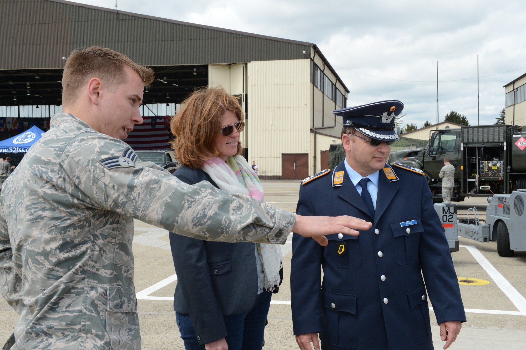 SPANGDAHLEM AIR BASE, Germany – U.S. Air Force Senior Airman Jon Casebolt, 52nd Equipment Maintenance Squadron armament cast member from Livingston, Mont., discusses aircraft munitions with German air force Lt. Col. Thomas Leibinger, 33rd Tactical Air Wing commander, and his wife, Christen, during Spangdahlem AB’s 60th Anniversary Celebration. The base hosted the event to commemorate the relationship between the United States and Germany since Spangdahlem AB’s creation May 10, 1953. (U.S. Air Force photo by Airman 1st Class Kyle Gese/Released)
