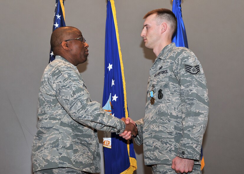 Brig. Gen. Allen Jamerson, U.S. Air Force Headquarters director of security forces, shakes hands with Staff Sgt. Dustin Taylor, 341st Security Forces Group security response leader, after presenting him with an Aerial Achievement Medal on May 7.  Taylor received the medal for performing duties as an Airborne Fire Team member for 52 PL-1 convoy missions.  (U.S. Air Force photo/John Turner)