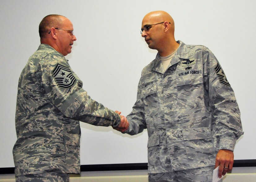 Chief Master Sgt. Michael Klausutis, right, the outgoing 919th Special Operations Wing command chief, is congratulated by his successor, Chief Master Sgt. Tom Mason, during the former’s sendoff event May 4, 2013 at Duke Field, Fla.  Since April 2009, Klausutis has served as the wing commander’s principal advisor on personnel issues affecting all 919th SOW enlisted Airmen. He was recently selected to become command chief for the new Air Force Special Operations Air Warfare Center at Hurlburt Field, Fla. (U.S. Air Force photo/Tech. Sgt. Jasmin Taylor)