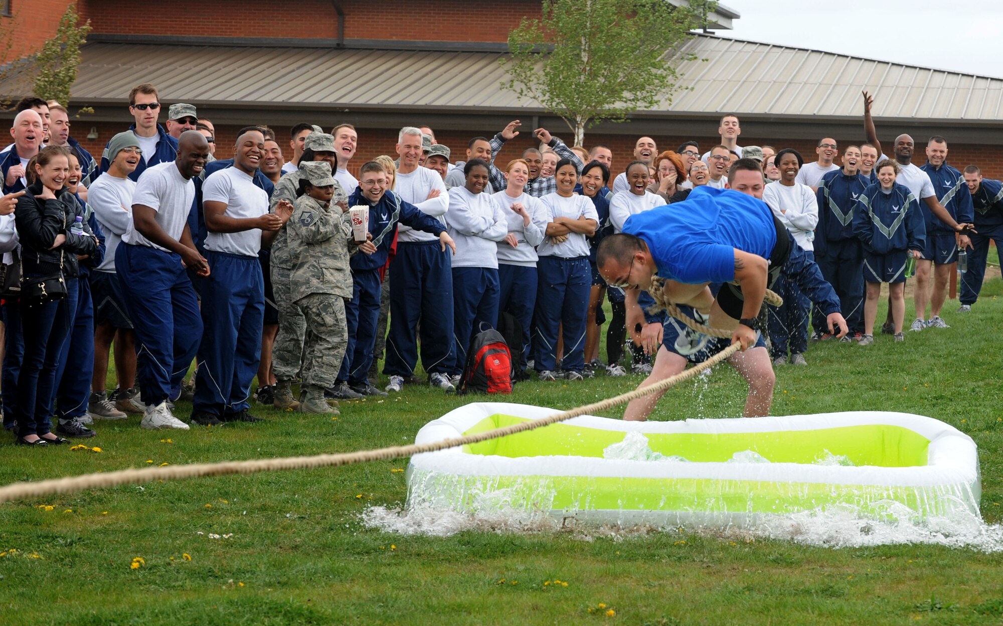 A Team Mildenhall member attempts to avoid a pool of water as his team is defeated at tug of war May 10, 2013, on RAF Mildenhall, England, during a post Unit Effectiveness Inspection sports challenge and barbeque.  Competitors were voted on to participate in different events by their peers.  (U.S. Air Force photo by Airman 1st Class Preston Webb/Released)