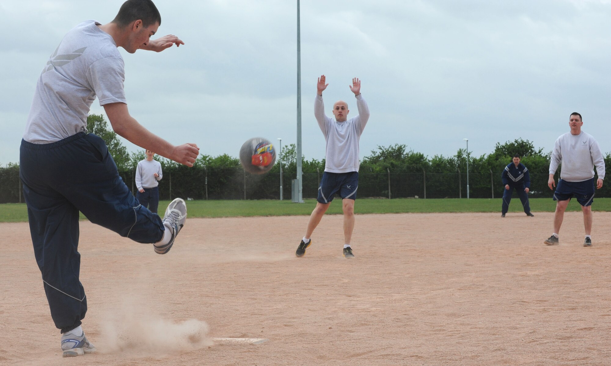 Team Mildenhall members play kick ball May 10, 2013, on RAF Mildenhall, England, during a post Unit Effectiveness Inspection sports challenge and barbeque. Challenges included arm wrestling, hurdles, kick ball, “Slip ‘n Slide” and tug of war. (U.S. Air Force photo by Airman 1st Class Preston Webb/Released)