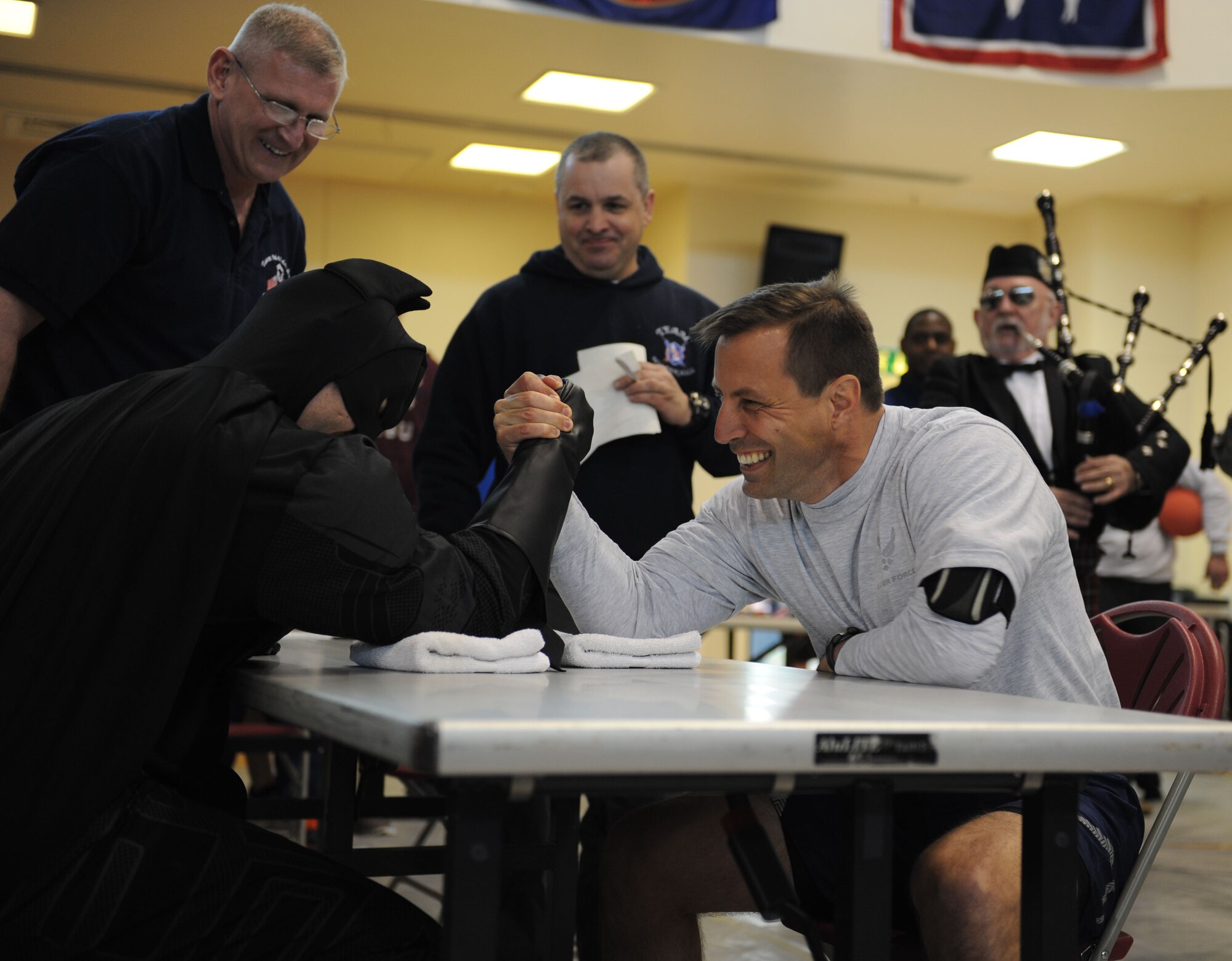 Master Sgt. Thomas Wagner, 100th Maintenance Squadron first sergeant in a superhero costume, arm wrestles Col. Christopher Kulas, 100th Air Refueling Wing commander, May 10, 2013, on RAF Mildenhall, England.  The arm wrestling tournament was one event that was part of a sports challenge during the post Unit Effectiveness Inspection celebration.  (U.S. Air Force photo by Airman 1st Class Preston Webb/Released)