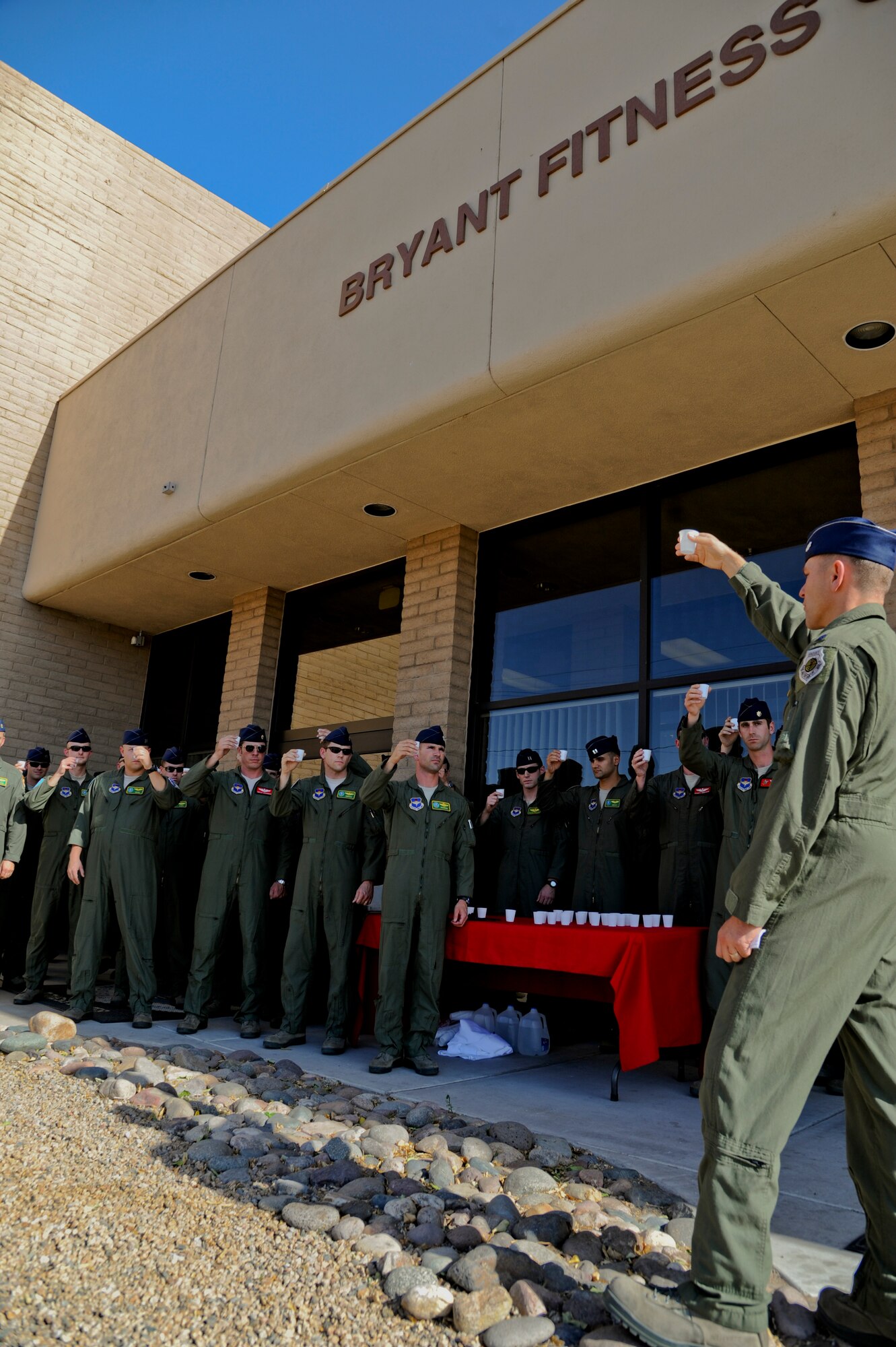 Members of the 310th Fighter Squadron raise their glasses in a toast to Lt. Col. Frank ”Bruiser” Bryant in front of the Luke Air Force Base Bryant Fitness Center April 26. Bryant was killed two years ago when an Afghan opened fire in a meeting at the Northern Kabul International Airport killing eight Airmen and one civilian. Bryant was deployed as an air advisor to the 438th Air Expeditionary Advisor Group in Kabul, Afghanistan. The fitness center was renamed in his honor. (U.S. Air Force photo/Staff Sgt. C.J. Hatch)