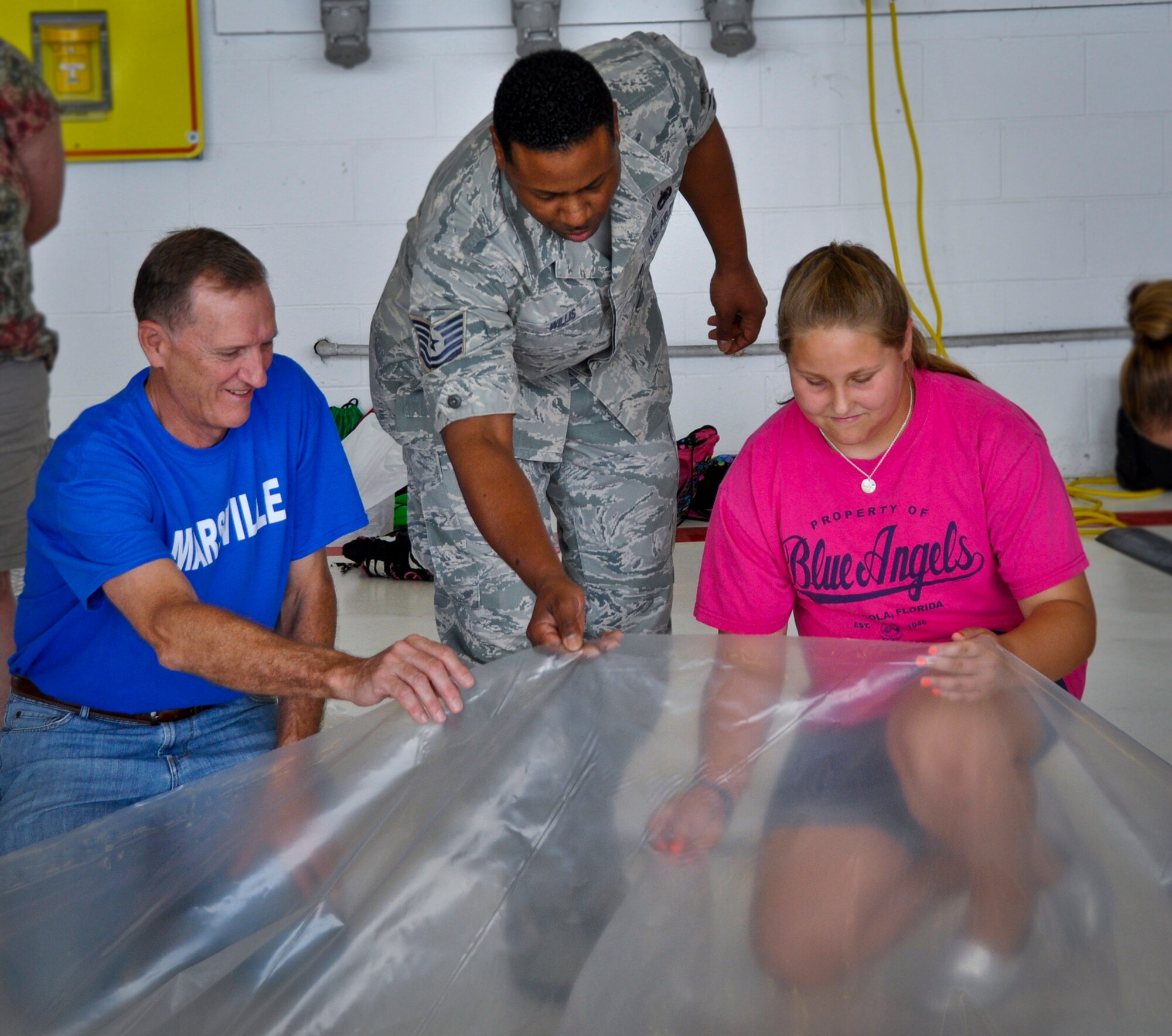 Tech Sgt. Andrew Willis, of the 96th Test Wing, assists a student from Baker Elementary in constructing their Mars habitat using plastic sheets and duct tape. The 18th annual Marsville program brought together fifth graders from four local schools to demonstrate how life might be sustained on Mars and remind the students of the importance of science, technology, engineering and math in their education. (U.S. Air Force photo/Sara Vidoni)