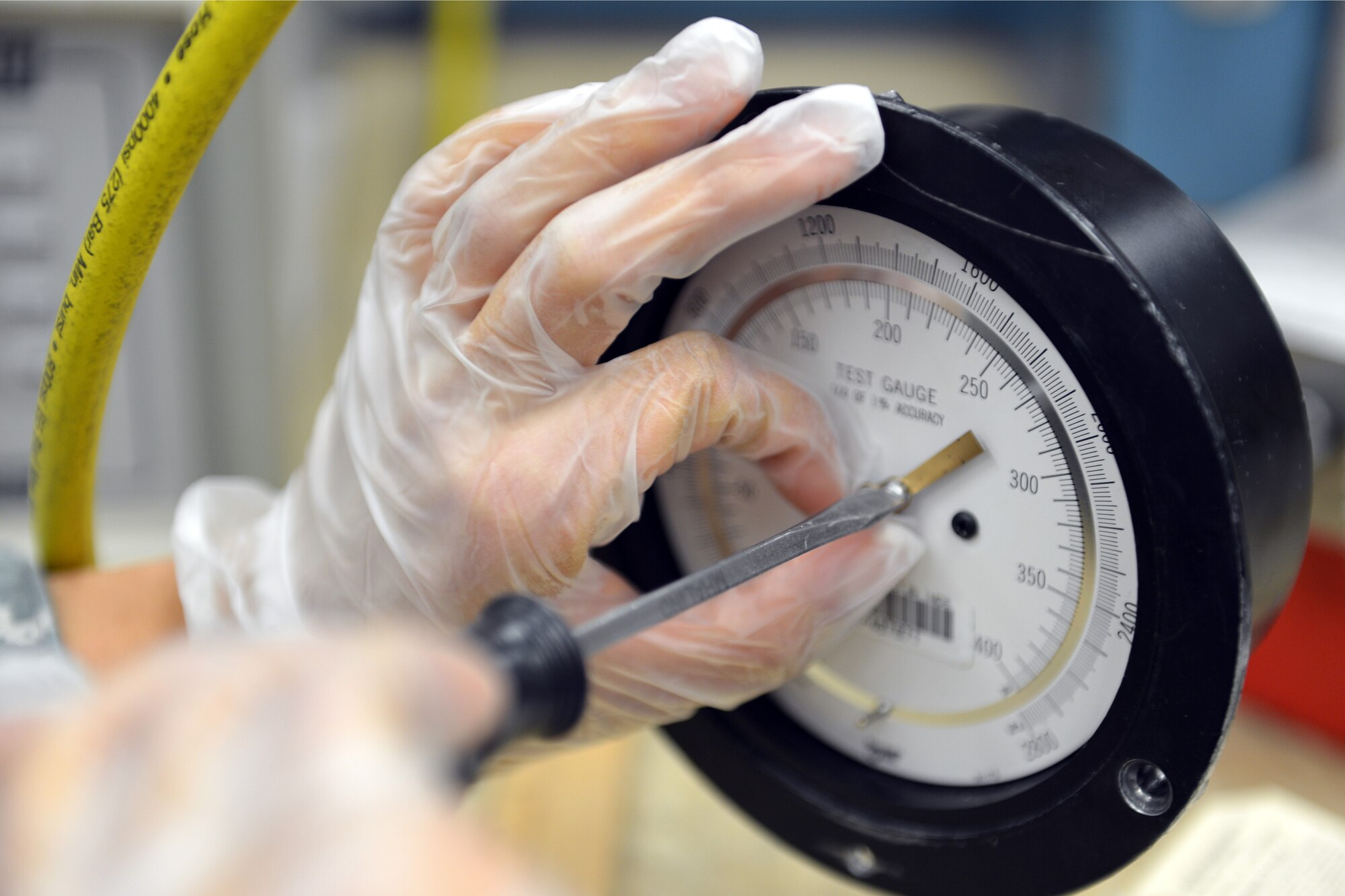 Staff Sgt. Mandy Shaddy, 62nd Maintenance Squadron Test Measurement Diagnostic Equipment Flight metrology technician, uses a screwdriver to adjust a needle on a fuel pump pressure gauge prior to calibrating it May 8, 2013 at Joint Base Lewis-McChord, Wash. The TMDE flight is responsible for ensuring defined accuracy and tolerance of JBLM’s complex electronic and physical dimensional test equipment such as fuel pressure gauges. (U.S. Air Force photo/Airman 1st Class Jacob Jimenez)