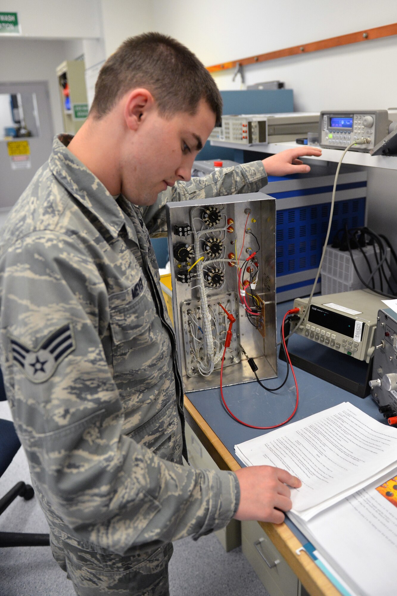Senior Airman Shawn Meyer, 62nd Maintenance Squadron Test Measurement Diagnostic Equipment Flight metrology technician, verifies instructions in an Air Force technical order while calibrating a countermeasure tester May 2, 2013 at Joint Base Lewis-McChord, Wash. Countermeasure testers are used to ensure aircraft flares will deploy with accurate timing. (U.S. Air Force photo/Airman 1st Class Jacob Jimenez)