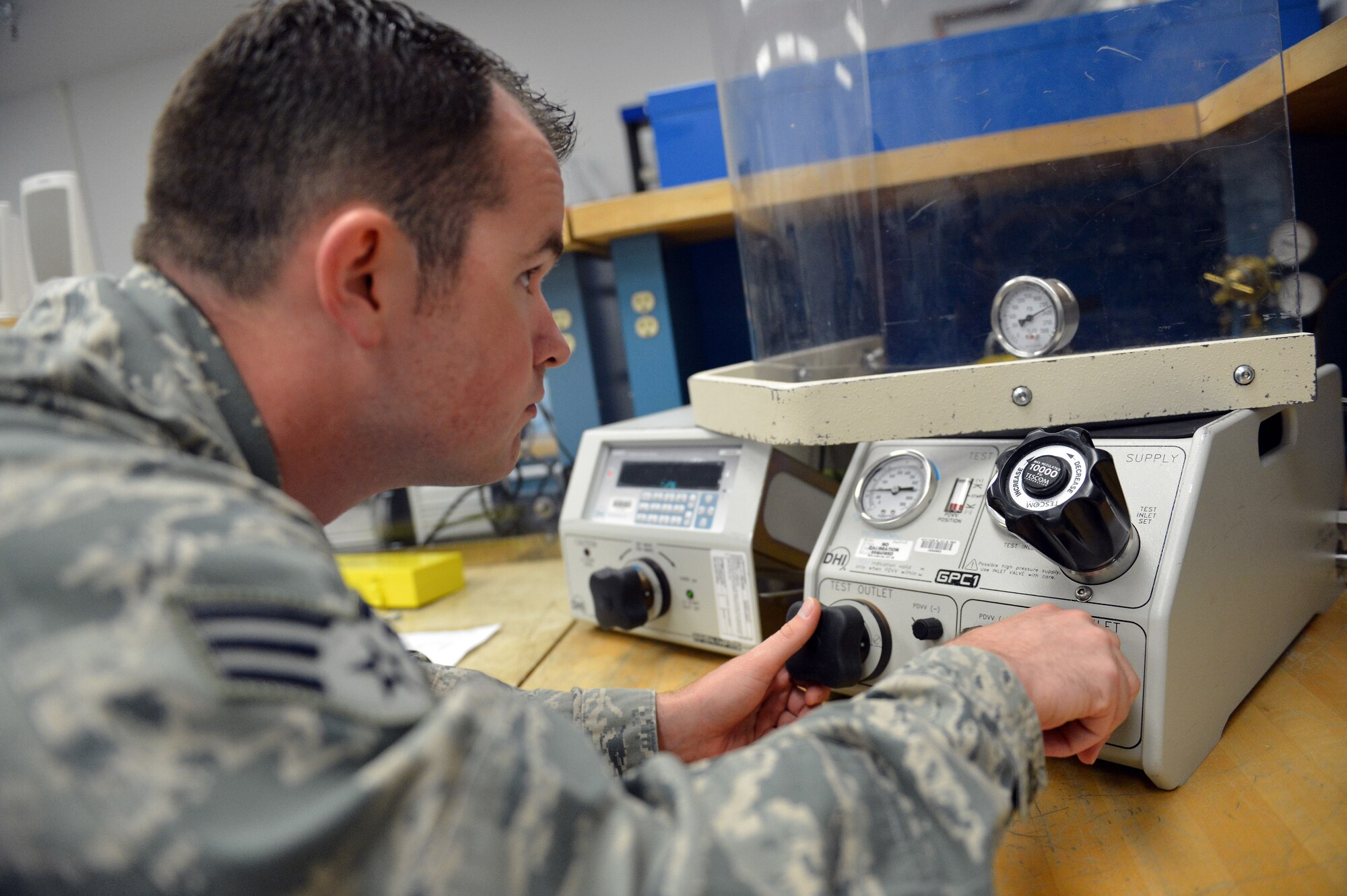 Senior Airman James Santos, 62nd Maintenance Squadron Test Measurement Diagnostic Equipment Flight metrology technician, compares air pressure readings during a calibration of an air pressure gauge May 2, 2013 at Joint Base Lewis-McChord, Wash. The TMDE flight calibrates hydraulic, gas, oil, pneumatic and water pressure gauges of equipment used throughout JBLM. (U.S. Air Force photo/Airman 1st Class Jacob Jimenez)