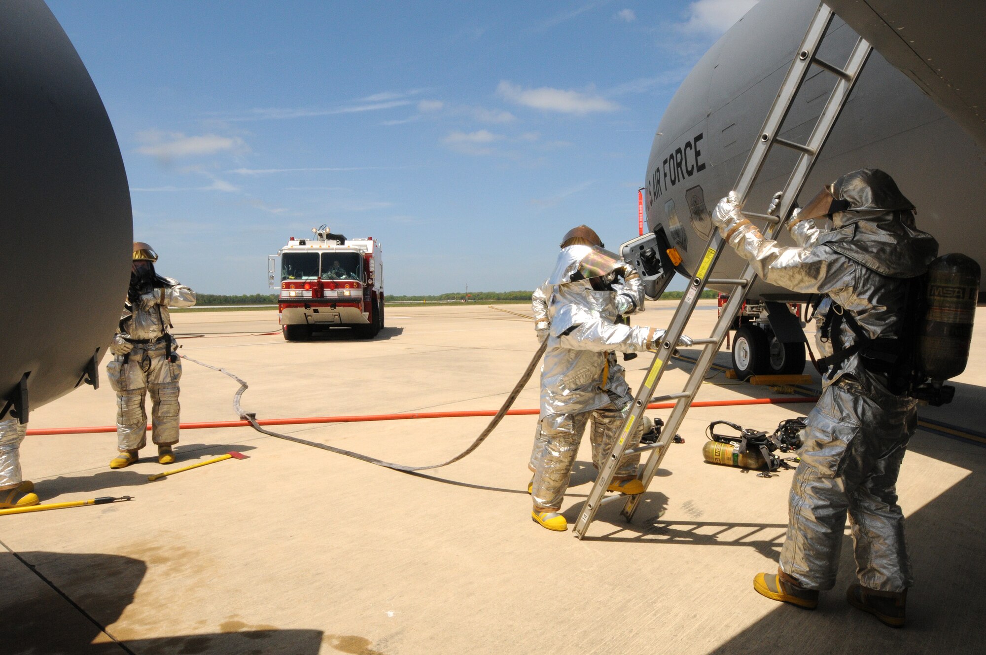 Airmen from the 459th Civil Engineer Squadron hold a ladder up the wing of a KC-135 Stratotanker during a training exercise at Joint Base Andrews Md., May 5, 2013. The team was exercising their capabilities to conduct a primary and secondary search and rescue for the scenario of smoke in the aircraft with one soul missing and simulated a Rapid Intervention Team standing by to assist them. (U.S. Air Force photo/ Tech. Sgt. Steve Lewis)