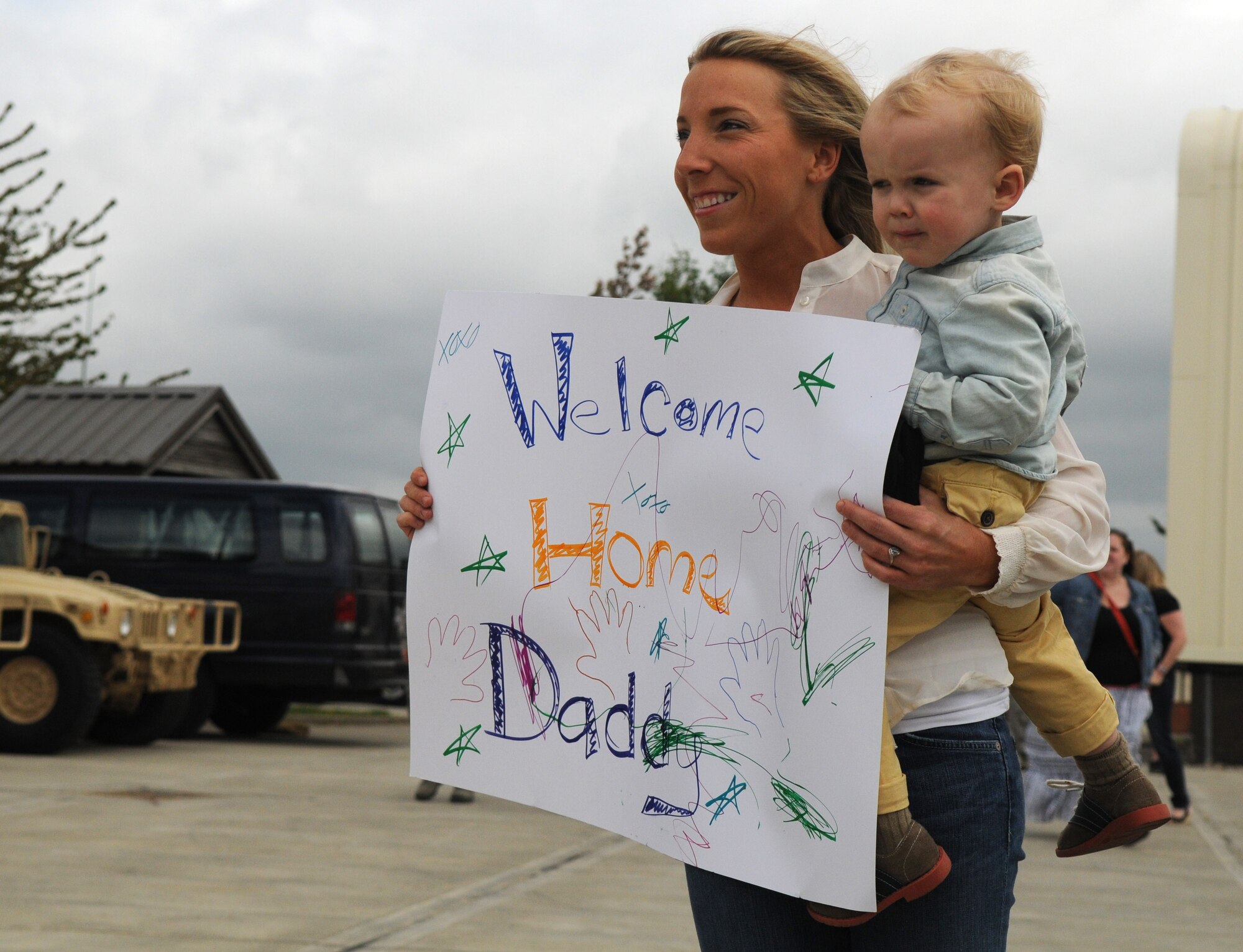 Autumn and Asher Fargher hold a sign welcoming Staff Sgt. Stephen Fargher, 100th Security Forces Squadron combined controller, home from a deployment May 10, 2013, at RAF Mildenhall, England. Fargher, from Springfield, Ore., and more than 30 other 100th SFS defenders returned home after being deployed to multiple locations worldwide for about six months. (U.S. Air Force photo/Staff Sgt. Austin M. May/Released)