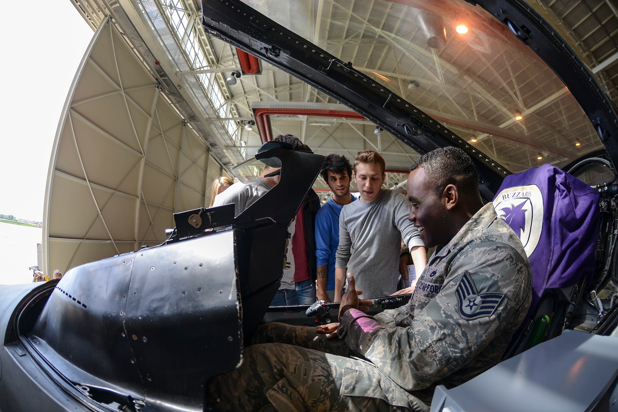 Staff Sgt. Caleb Pearson, 31st Maintenance Group squadron lead crew chief, shows a group of Italian and American students the inside of an F-16 Fighting Falcon cockpit during a base tour at Aviano Air Base, Italy. During the tour, Italian and American students alike were able to practice their language skills in a social situation and learn more about one another’s cultures. (U.S. Air Force photo/ Staff Sgt Katherine Tereyama)