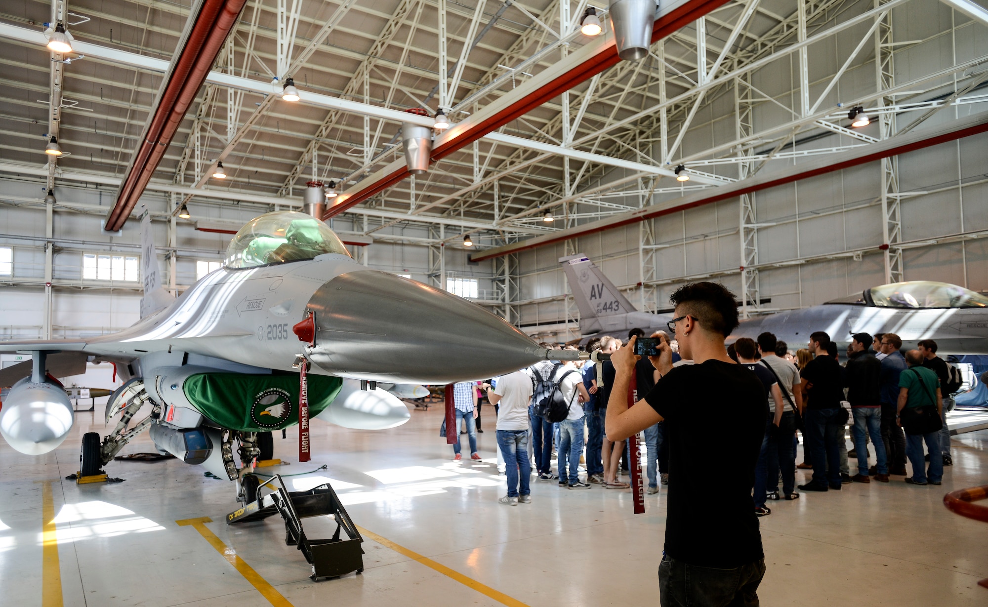 An Italian student from Leonardo da Vinci Technical Institute takes a picture of an F-16 Fighting Falcon during a base tour May 9 at Aviano Air Base, Italy. While students frequently tour the base, this is the first time Italian and American students have toured together in several years. (U.S. Air Force photo/Staff Sgt. Katherine Tereyama)