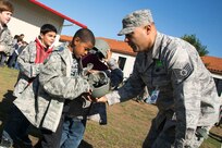 Tech. Sgt. Joseph Trevino hands a student from Randolph Elementary School a helmet during Operation FLAGS May 2 at Joint Base San Antonio-Randolph. (Air Force photo by Joshua Rodriguez/ Released)