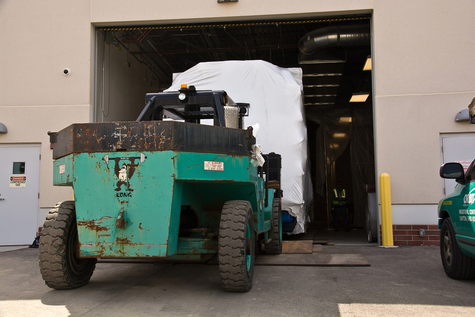 Forklifts carry the Research Altitude Chamber into Building 850.  Photo credit: Mr. Rick Eldridge.