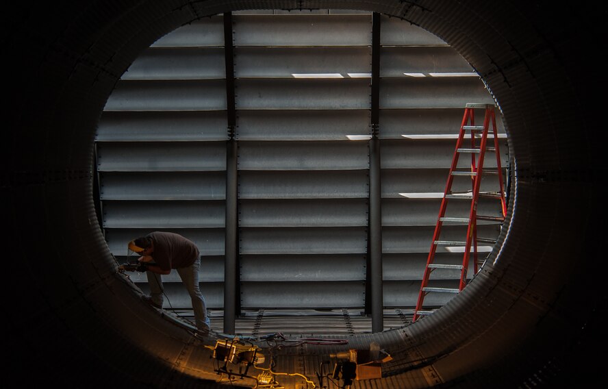 A contractor replaces studs in a T-9 jet engine test facility augmenter during a renovation project May 1, 2013, at Dyess Air Force Base, Texas. The almost 20 year old facility will receive a complete restoration to increase noise suppression and decrease the potential of foreign object debris. (U.S. Air Force photo by Senior Airman Jonathan Stefanko/Released)
