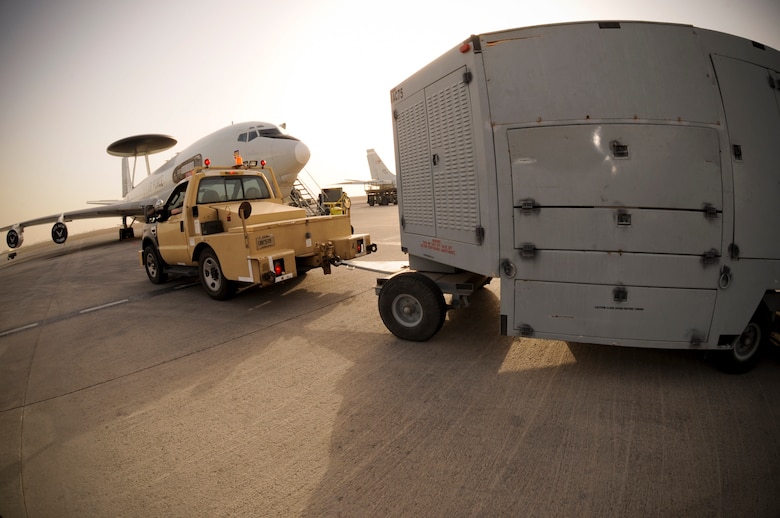 U.S. Air Force Senior Airman Brian Bloomer, 380th Expeditionary Maintenance Squadron Aerospace Ground Equipment journeyman, delivers an ACE air conditioner unit May 9, 2013 to an E-3 Sentry. The AWACS requires this heavy-duty air conditioner to keep its systems cool enough for maintainers to perform preventive maintenance. Bloomer is a native of Maquon, Ill., and is deployed from Mountain Home Air Force Base, Idaho. (U.S. Air Force photo by Staff Sgt. Joshua J. Garcia)  