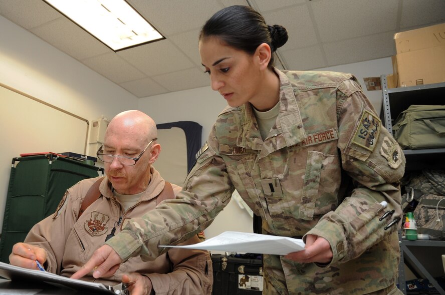 1st Lt. Wajeeha Omar, 455th Expeditionary Medical Operations Squadron patient movement nurse, discusses inbound patient records with Lt. Col. (Dr.) Dave Hardy, 455th EMDOS chief of aerospace medicine, at the Craig Joint Theater Hospital on Bagram Airfield, Afghanistan, May 9, 2013. Deployed from Lackland Air Force Base, Texas, Omar is responsible for the efficient movement of patients into the hospital and either back to their downrange units or to further care outside the area of operations. (U.S. Air Force photo/Staff Sgt. David Dobrydney)