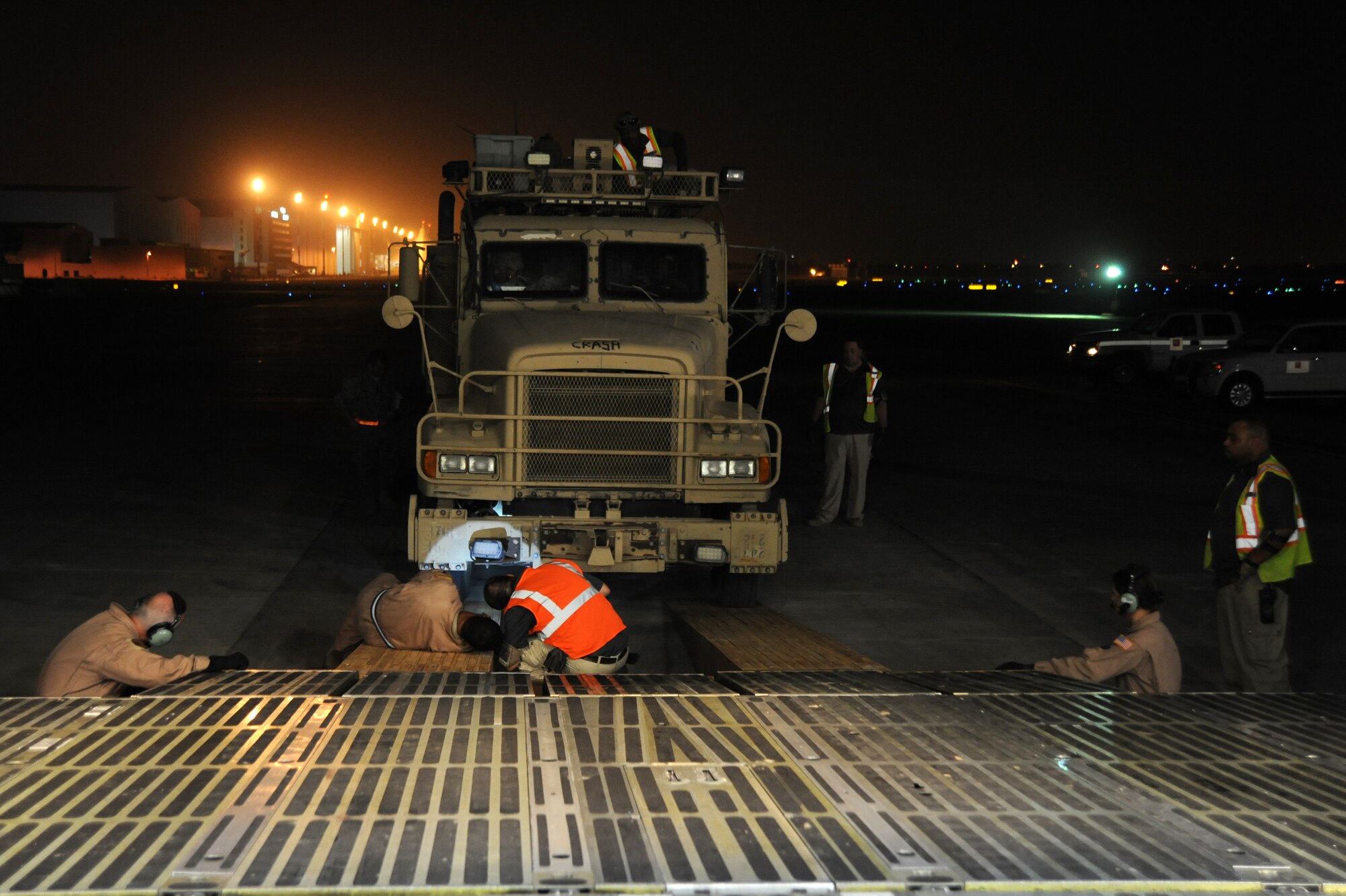Tech. Sgt Antonio Little, 9th Airlift Squadron, loadmaster and Mr. Ronald Fine, Louis Berger Services, general manager takes a final look at the tire alignment before rolling the 87,000 pound Granutech Mobile Rotogrind Shredder Model 525 HP into a C-5M Super Galaxy May 8, 2013 at an undisclosed airfield, Southwest Asia. (U.S. Air Force photo/Senior Master Sgt. George Thompson)