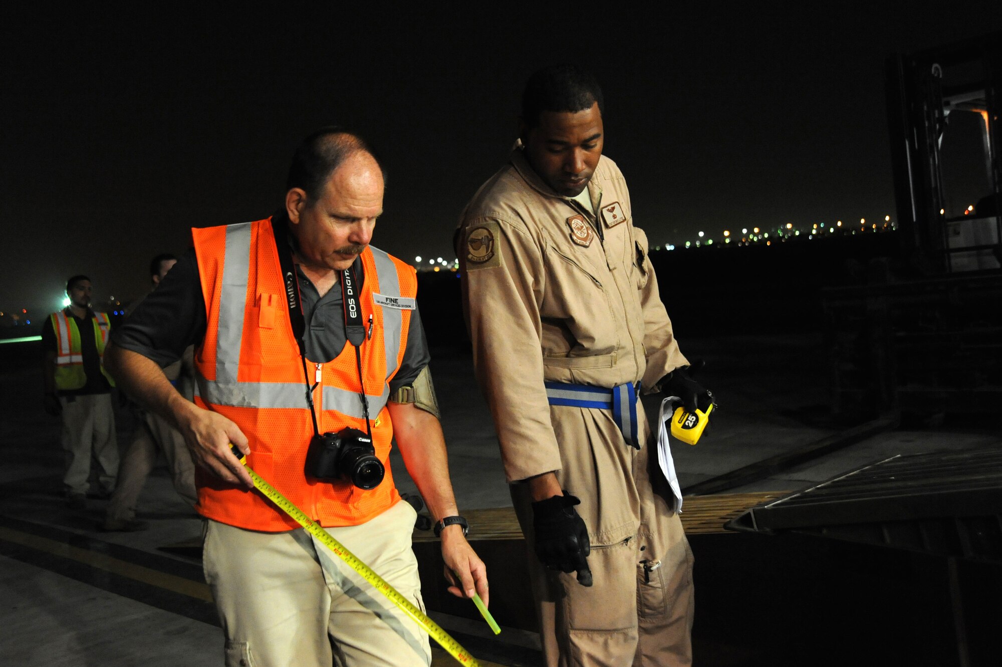 Mr. Ronald Fine, Louis Berger Services, general manager and Tech. Sgt Antonio Little, 9th Airlift Squadron, loadmaster take final measurements before loading the 87,000 pound Granutech Mobile Rotogrind Shredder Model 525 HP into a C-5M Super Galaxy May 8, 2013 at an undisclosed airfield, Southwest Asia. (U.S. Air Force photo/Senior Master Sgt. George Thompson)