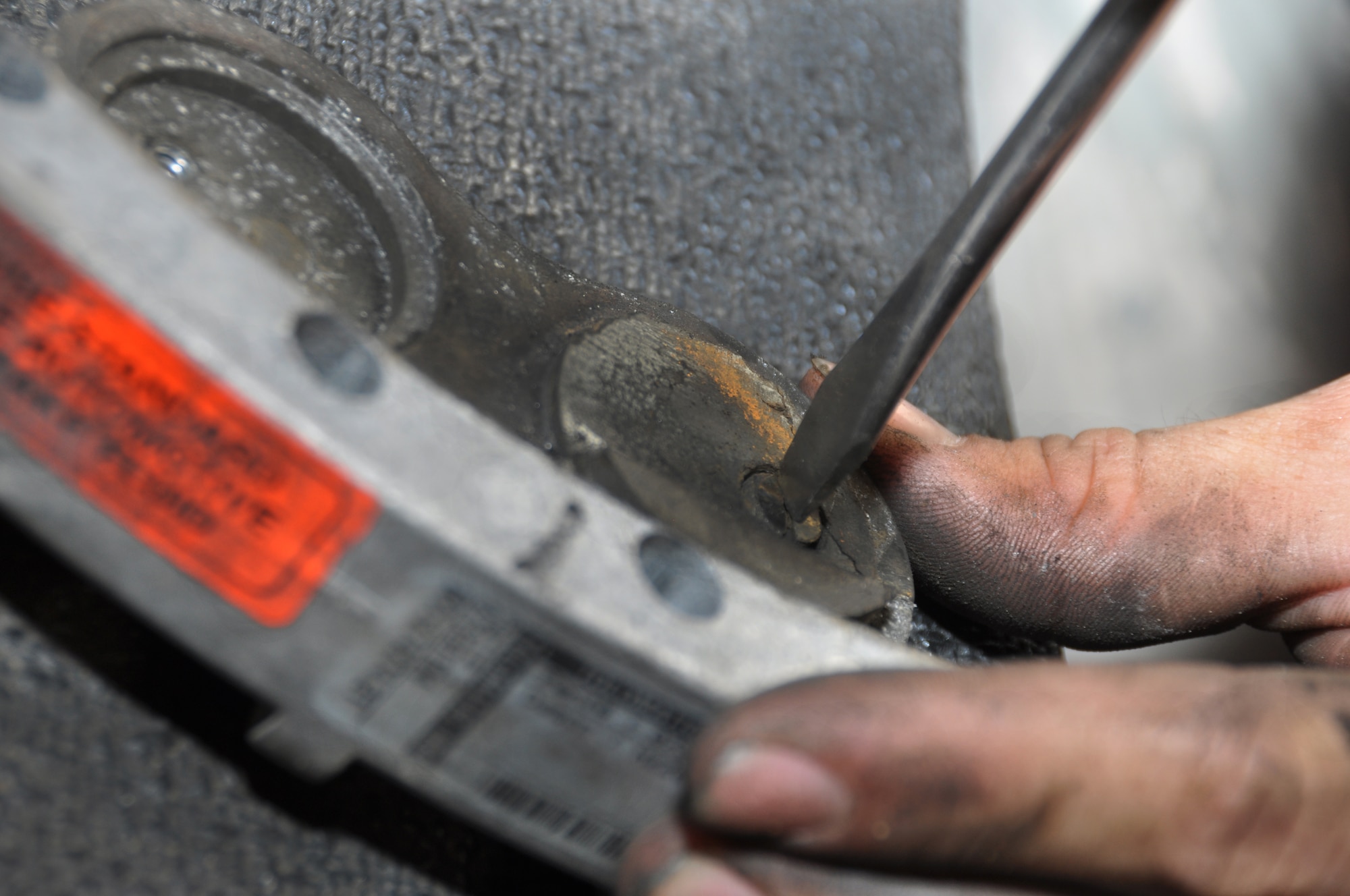 U.S. Air Force Airman 1st Class Stephen Zeiler, 380th Expeditionary Maintenance Squadron Aerospace Ground Equipment journeyman,removes the brake pad from an  MJ-1B Bomblift brake assembly May 8, 2013, during a periodic inspection here. Periodic inspections are "tune-ups" for the equipment, enabling the delivery of more than 7,000 pieces of AGE to aircraft on the flightline monthly. Zeiler is a native of Antioch, Calif., and is deployed from Elmendorf Air Force Base, Alaska. (U.S. Air Force photo by Staff Sgt. Timothy Boyer)