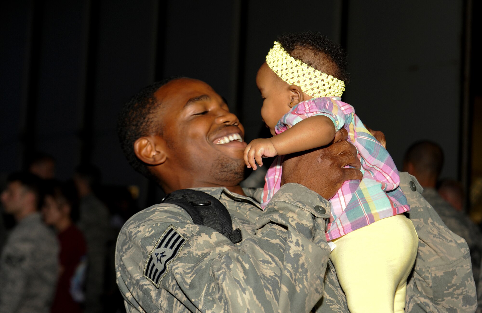 U.S. Air Force Staff Sgt. Jaypaul Gaubault, 18th Aircraft Maintenance Squadron crew chief, embraces his daughter for the first time on Kadena Air Base, Japan, May 9, 2013, after returning from a deployment. More than 60 Airmen returned from the eight-month deployment. The homecoming also had a bouncy castle for children to play in as they waited for their loved ones. (U.S. Air Force photo by Airman 1st Class Malia Jenkins/Released)   