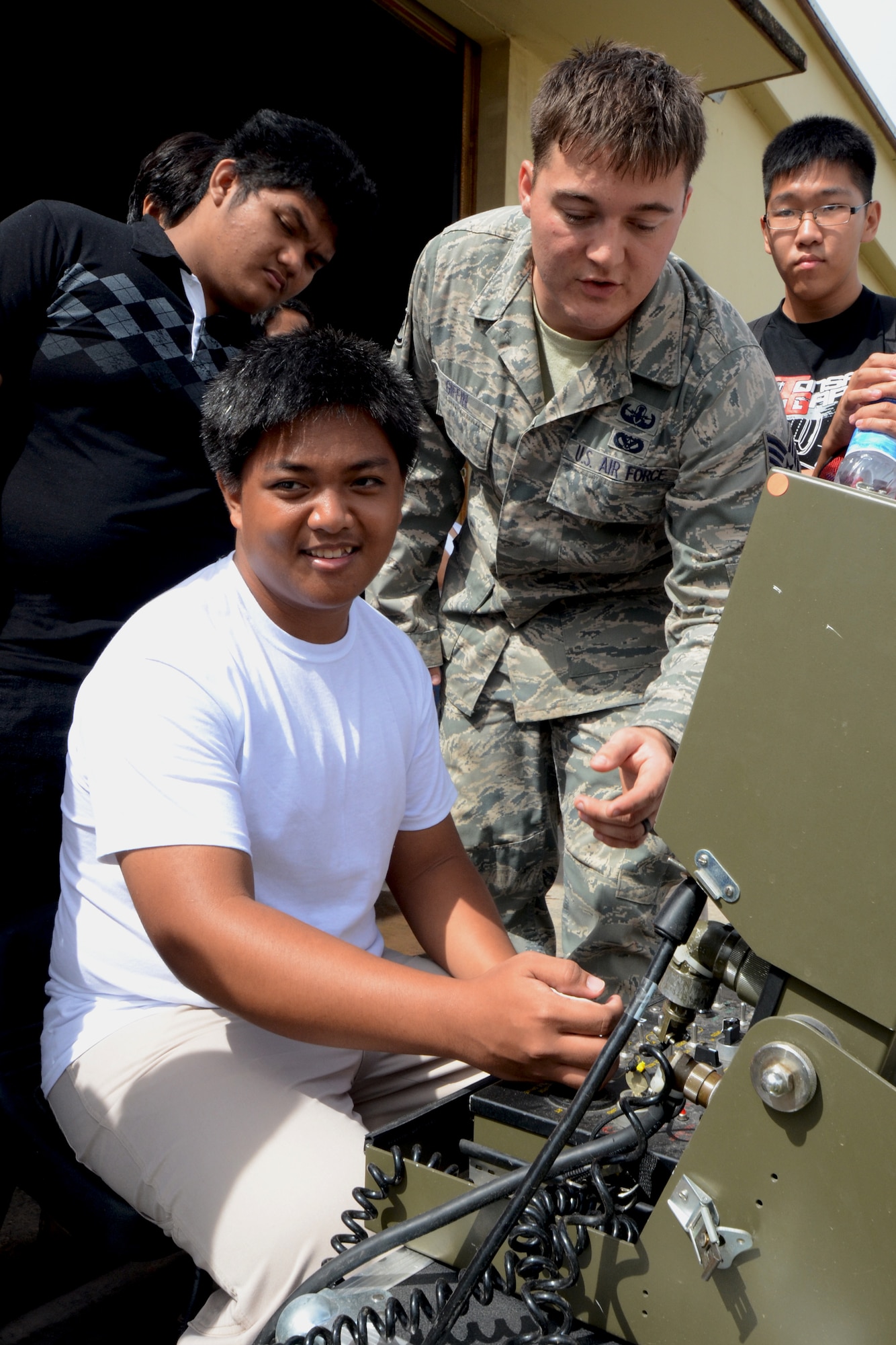 Staff Sgt. Kameron Giffin, 36th Civil Engineer Squadron Explosive Ordnance Disposal training NCO in charge, assists a student in operating a F6A EOD robot at the EOD complex on Andersen Air Force Base, Guam, May 1, 2013. Forty-Three students took a field trip to the complex as part of their current history curriculum in World War II history and the Pacific Islands. (U.S. Air Force photo by Staff Sgt. Benjamin Wiseman/Released) 
