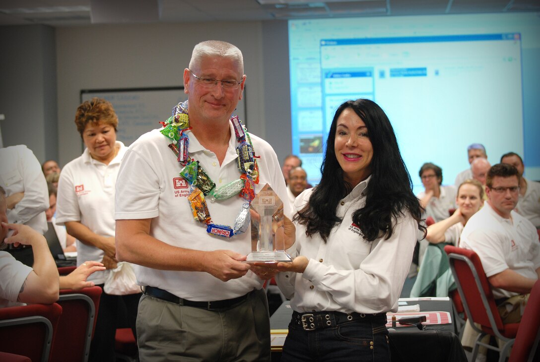 The U.S. Army Corps of Engineers (USACE) announced that Drew Benziger, Chief of Pacific Ocean Division’s Readiness Contingency Operations, is the 2011 USACE Emergency Manager of the Year.  Surrounded by his emergency management peers while attending a workshop in Mobile, Ala., Benziger (left) receives the award from Karen Durham-Aguilera, who is the Director of Contingency Operations and Office of Homeland Security, Headquarters, USACE.