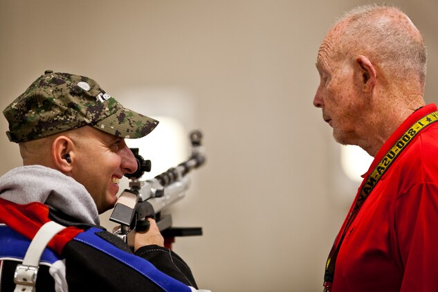 Former Marine Staff Sgt. Matthew Benack, native of Arnold, Miss., chats with his shooting coach during air rifle practice for the last year's Warrior Games in Colorado Springs, Colo.