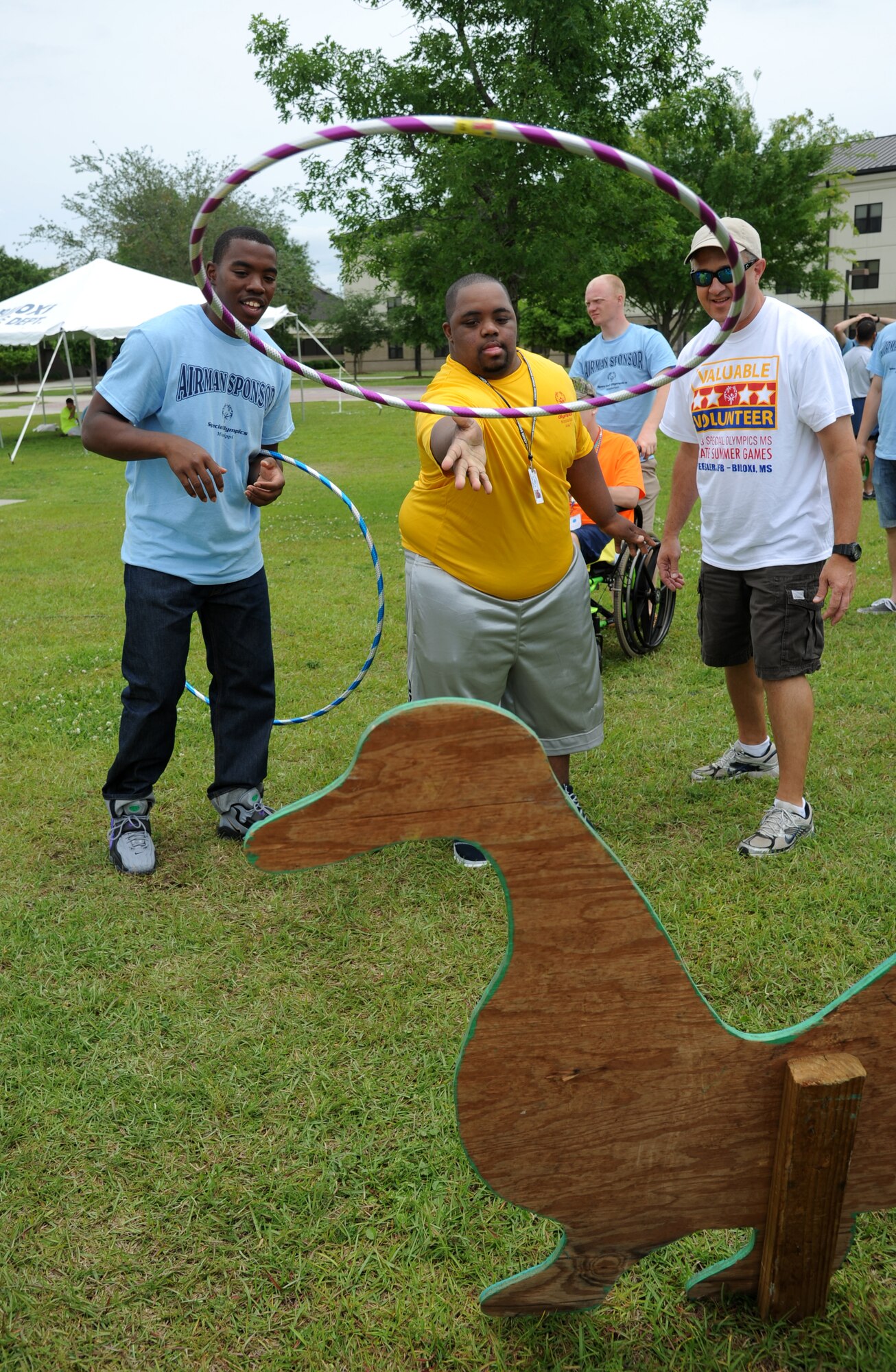 James Carter (center), athlete, plays a game of ringasaurus as he is cheered on by Airman 1st Class Dimitri Smith, 338th Training Squadron sponsor, and Dean Collins, volunteer, during the Special Olympics Mississippi Summer Games on May 11, 2013, at Keesler Air Force Base, Miss.  More than 900 athletes and 3,000 volunteers worked together to hold competitions throughout the day.  This is the 27th year Keesler has hosted the state Special Olympics.   (U.S. Air Force photo by Kemberly Groue)