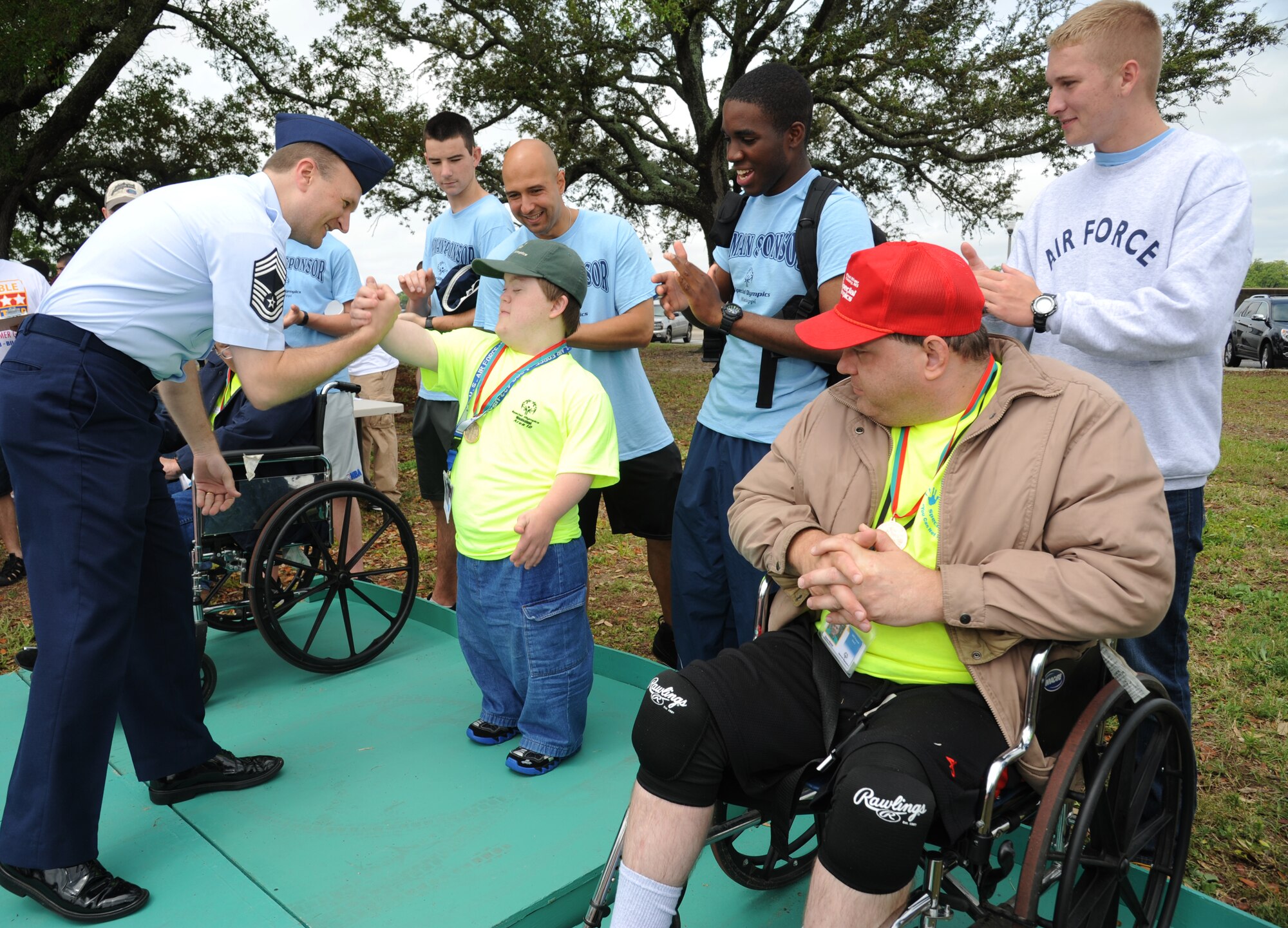 Chief Master Sgt. Michael Wood, 81st Medical Group command chief, congratulates Austin Seymour for winning a gold medal during the Special Olympics Mississippi Summer Games on May 11, 2013, at Keesler Air Force Base, Miss.  More than 900 athletes and 3,000 volunteers worked together to hold competitions throughout the day.  This is the 27th year Keesler has hosted the state Special Olympics.   (U.S. Air Force photo by Kemberly Groue)