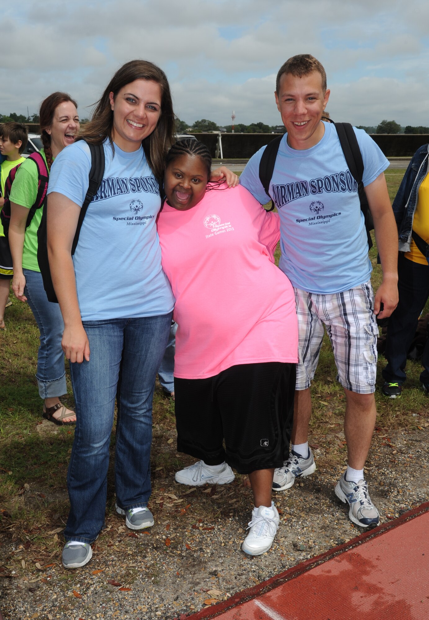 Khadeijah Barnes (center), athlete, takes a photo with her sponsors, Airman 1st Class Marie Williams and Airman Basic Anthony Portale, 338th Training Squadron, after Barnes completed the 25-meter assisted walk during the Special Olympics Mississippi Summer Games on May 11, 2013, at Keesler Air Force Base, Miss.  More than 900 athletes and 3,000 volunteers worked together to hold competitions throughout the day.  This is the 27th year Keesler has hosted the state Special Olympics.   (U.S. Air Force photo by Kemberly Groue)