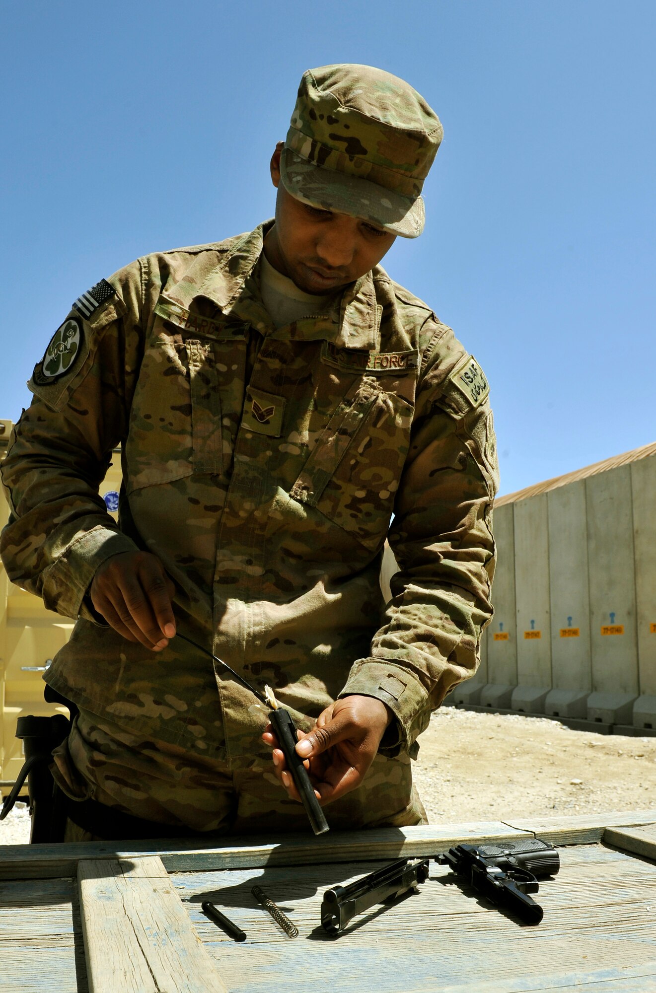 Senior Airman Quentin Hardy cleans his M9 pistol prior to returning it to the armory on Bagram Airfield, Afghanistan, May 11, 2013. During the return process, all members weapons are inspected for cleanliness before the  turn-in is complete.  (U.S. Air Force photo/ Staff Sgt. Stephenie Wade)