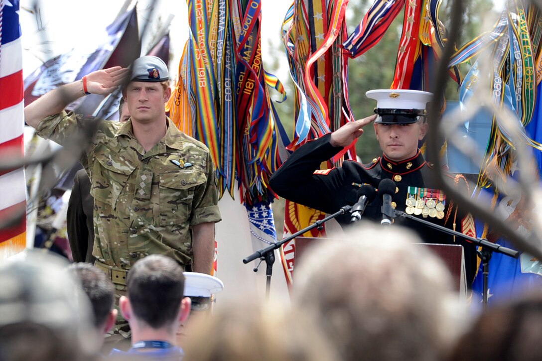 Britain's Prince Harry and emcee U.S. Marine Staff Sgt. Joshua Miles salute during the playing of the national athems at the 2013 Warrior Games opening ceremony at the U.S. Olympic Training Center in Colorado Springs, Colo., May 11-17.  U.S. Olympic Training Center and U.S. Air Force Academy, wounded, ill and injured servicemembers and veterans from the U.S. Marines, Army, Air Force and Navy, as well as a team representing U.S. Special Operations Command and an international team representing the United Kingdom, will compete for the gold in track and field, shooting, swimming, cycling, archery, wheelchair basketball and sitting volleyball. The military service with the most medals will win the Chairman's Cup.