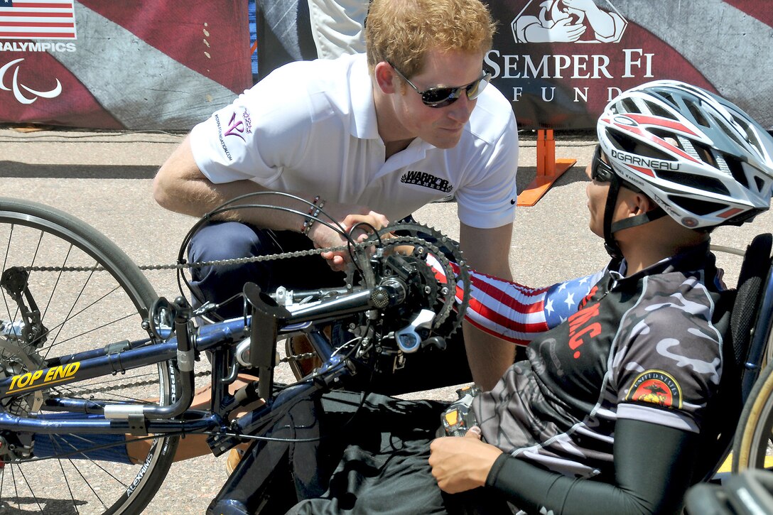 Prince Harry offers words of encouragement and shakes hands with 2013 Warrior Games recumbent bike cyclist Marine veteran Josue Barron before the start of the 2013 Warrior Games cycling competition near the U.S. Air Force Academy in Colorado Springs, Colo., May 11. From May 11-16, more than 200 wounded, ill and injured servicemembers and veterans from the U.S. Marines, Army, Air Force and Navy, as well as a team representing U.S. Special Operations Command and an international team representing the United Kingdom, will compete for the gold in track and field, shooting, swimming, cycling, archery, wheelchair basketball and sitting volleyball at the U.S. Olympic Training Center and U.S. Air Force Academy. The military service with the most medals will win the Chairman's Cup.