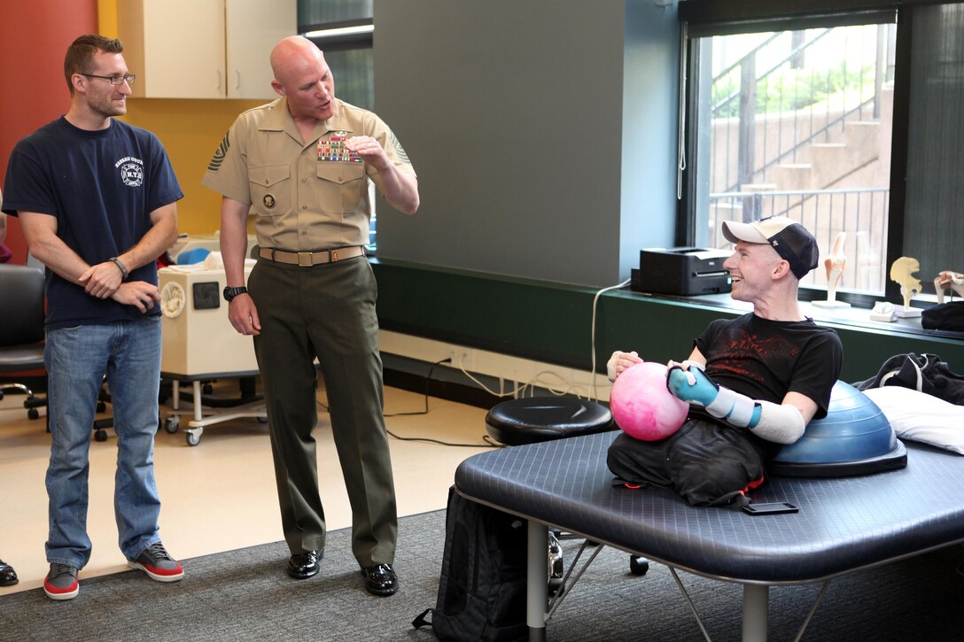 Sgt. Maj. Micheal P. Barrett, the 17th Sergeant Major of the Marine Corps, speaks to retired Army Sgt. Brendan M. Marrocco during a visit to Johns Hopkins Medical Center in Baltimore, Md., on May 8, 2013. Marrocco is a quadruple amputee who received a bilateral arm transplant. (U.S. Marine Corps photo by Sgt. Marionne T. Mangrum)