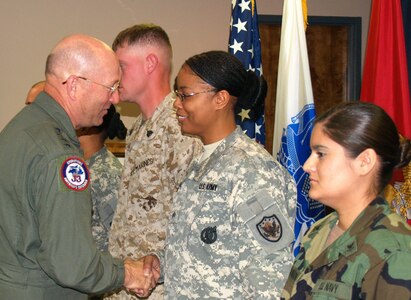 NORAD, USNORTHCOM Commander visits JTF North - April 24, 2007 - General Gene Renuart, commander of North American Aerospace Defense Command and U.S. Northern Command, presents his coin to Army Sgt. Tanikannia I. Hollis, Joint Task Force North plans and policy directorate noncommissioned-officer-in-charge, during an April 24 visit to Joint Task Force North headquarters at Fort Bliss, Texas. JTF North is the USNORTHCOM organization tasked to support the nation’s federal law enforcement agencies in the identification and interdiction of suspected transnational threats within and along the approaches to the continental United States.